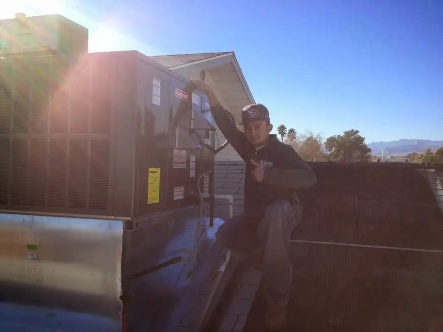 HVAC technician performing Heat Pump Repair on a rooftop unit in Novato